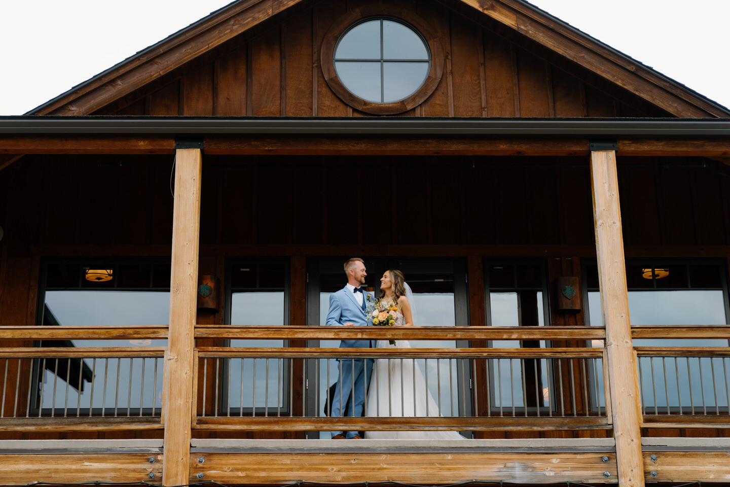 Bride and groom on balcony at Aspen Lakes Golf Course.