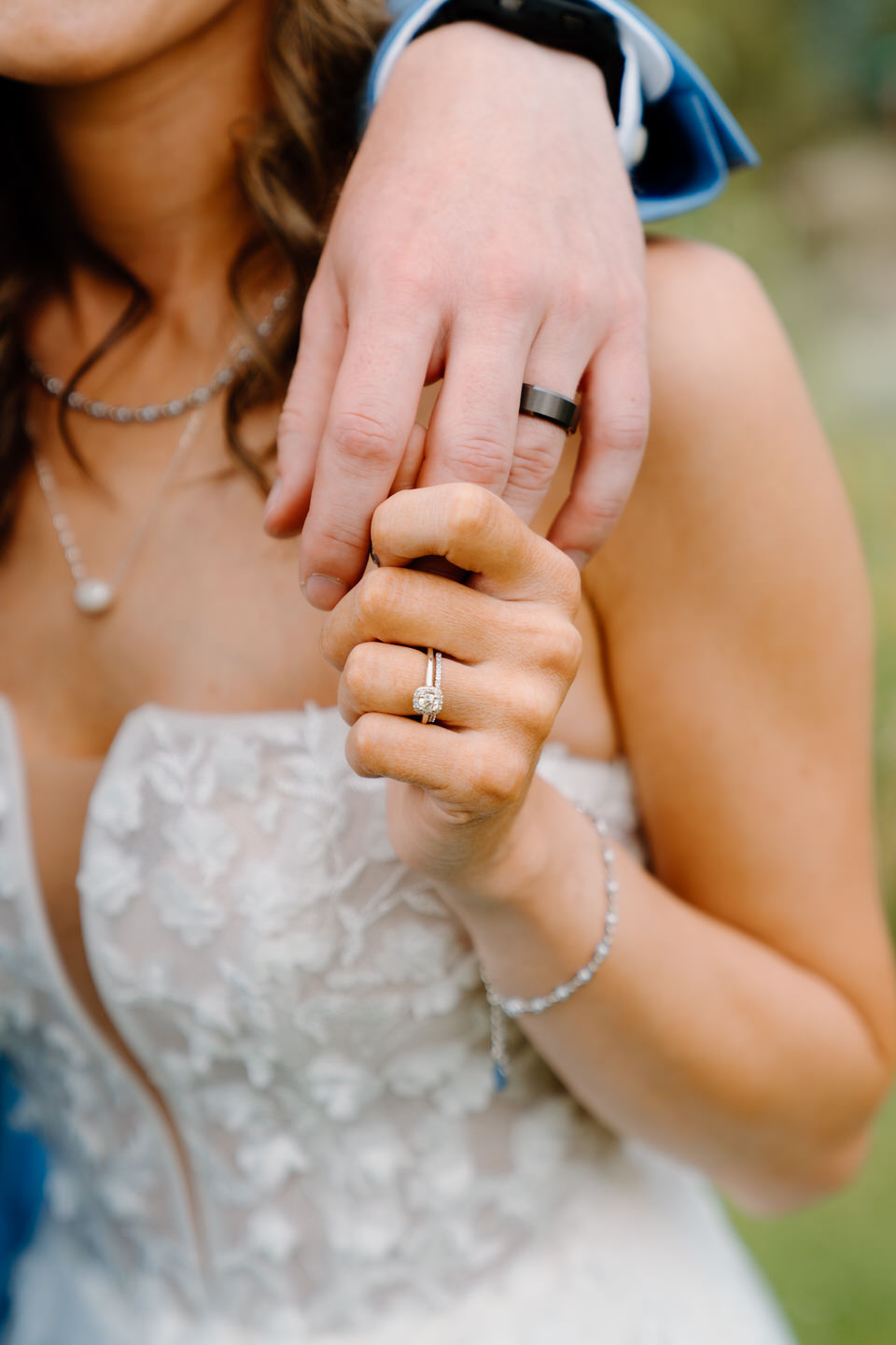 Wedding rings with couple holding hands in Sisters, Oregon.