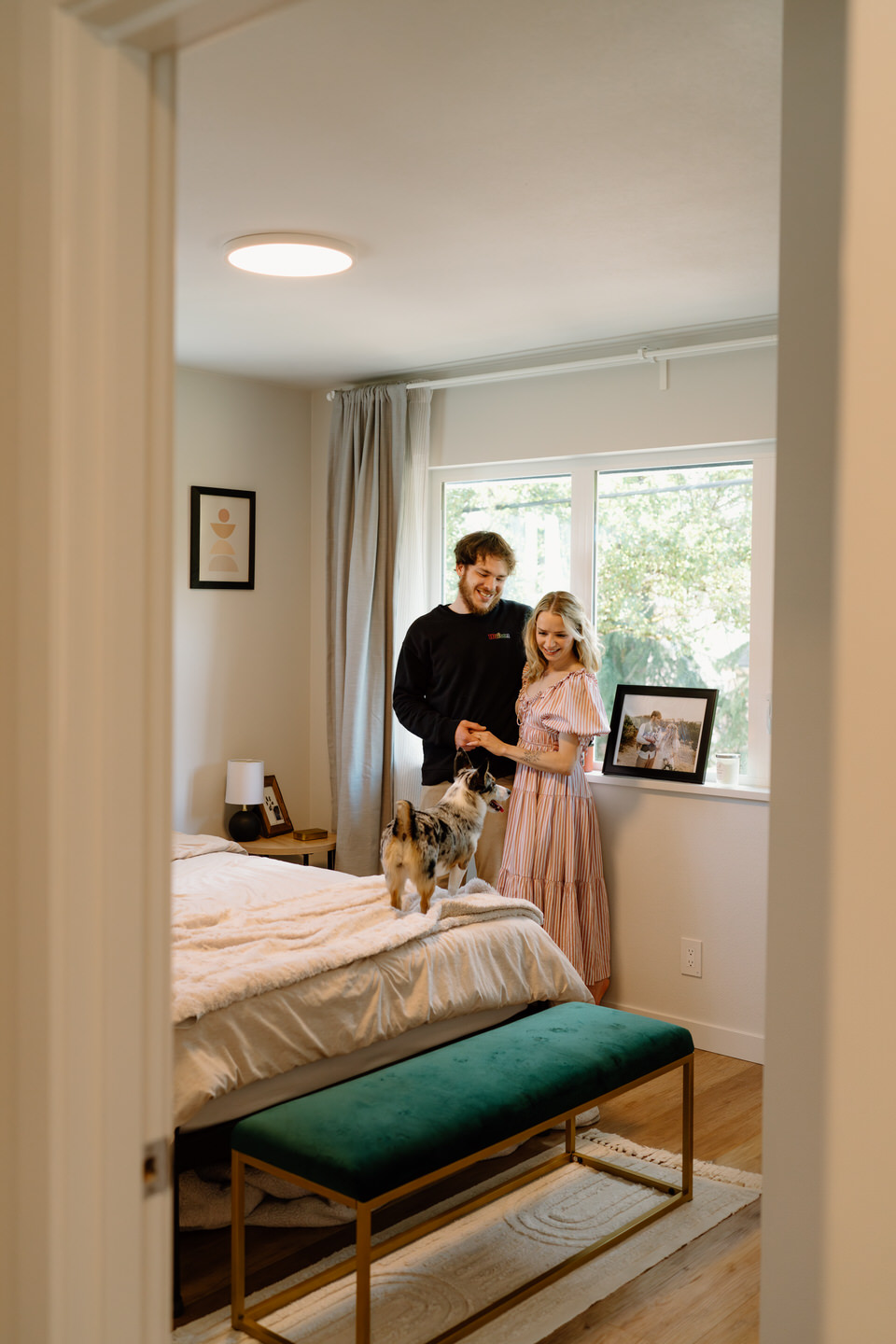 Couple embracing in the bedroom of their new home with their dog