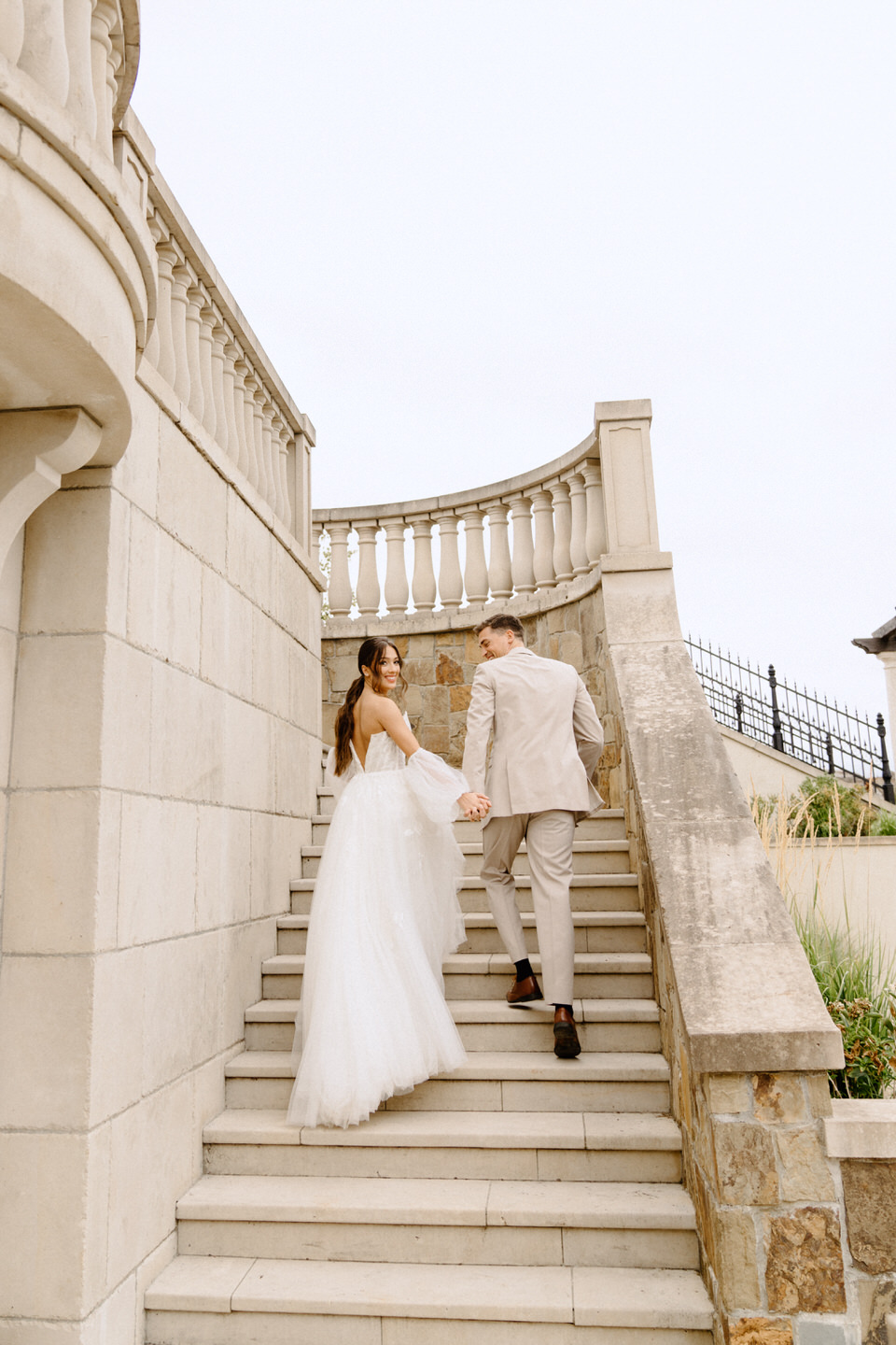 Bride and groom walking up the stairs at the Chateau de Lis