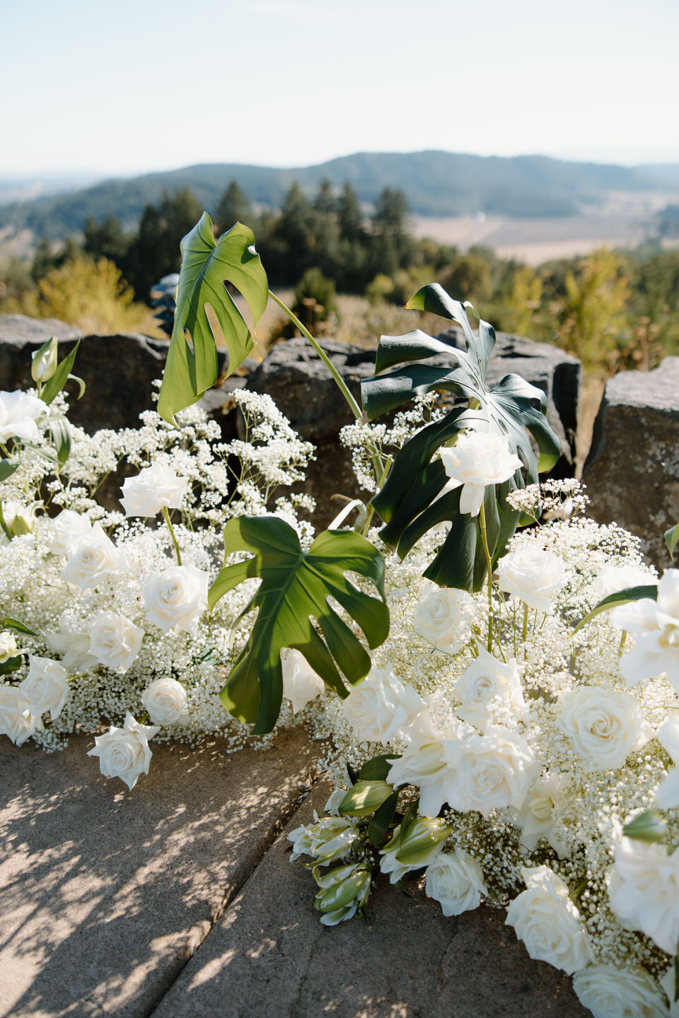 Luxury wedding flowers with monstera plants and white flowers.