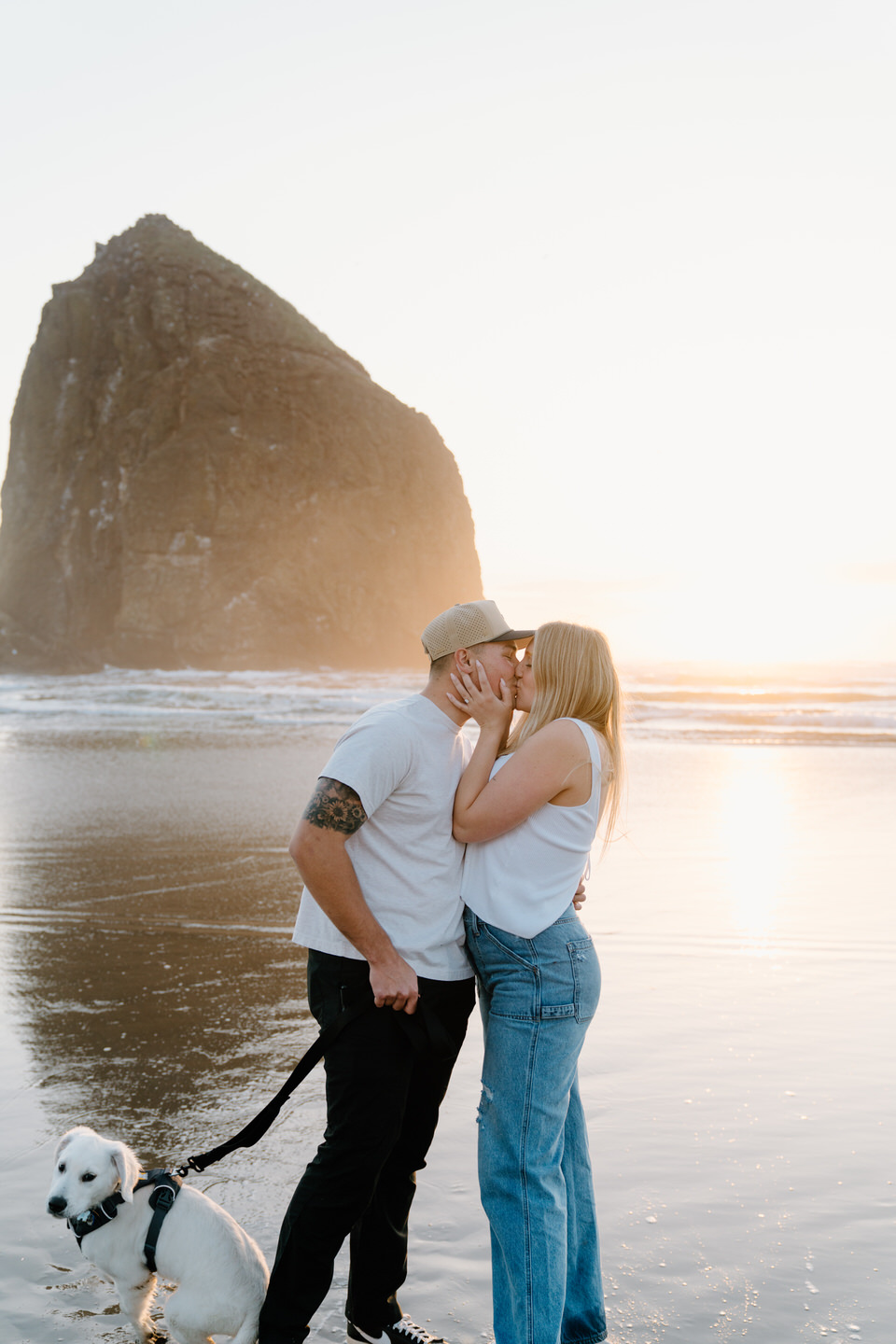 Couple in front of Haystack rock with their puppy