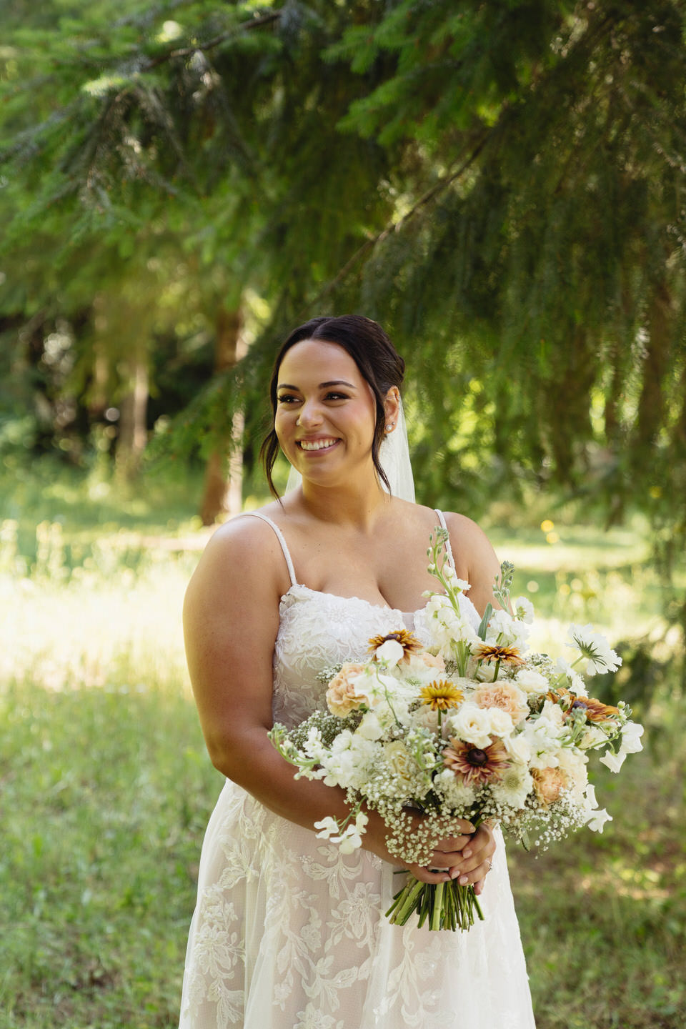 Bride smiles with her bridal bouquet