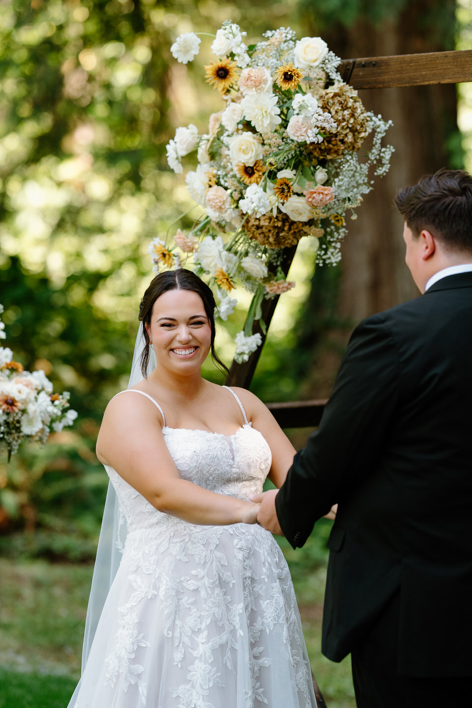 Bride looks at guests during wedding ceremony at Springwater Lakes Estate