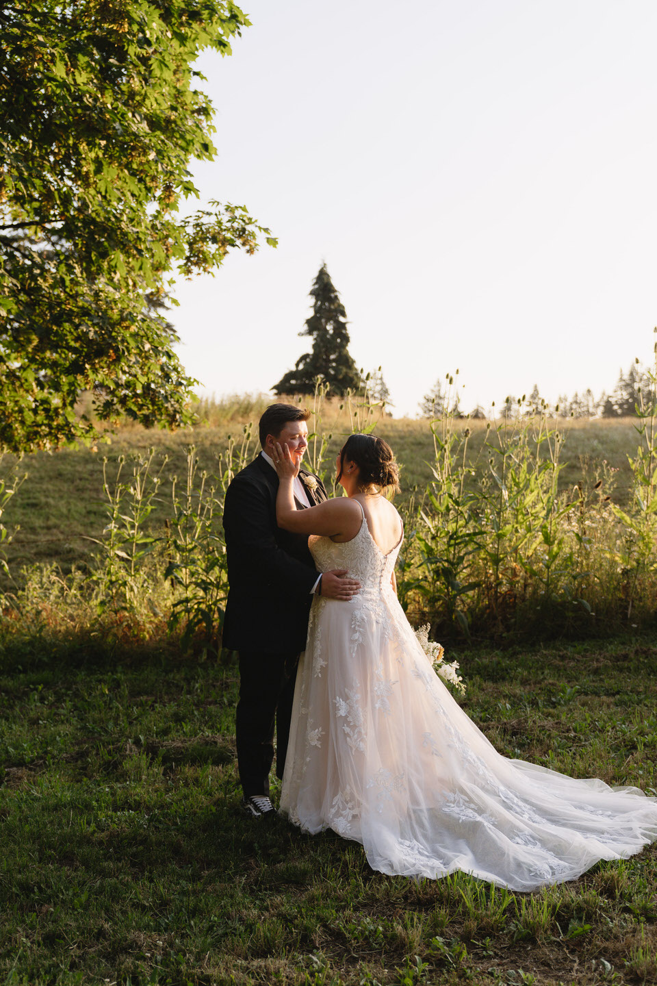 Bride and groom in front of a field