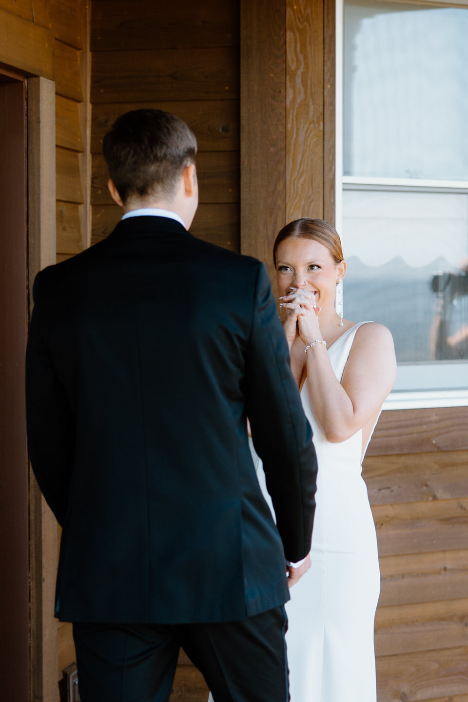 Bride and groom see each other for the first time during their first look on the porch