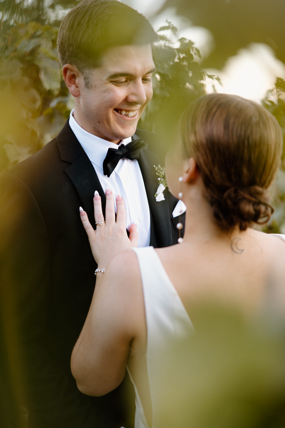 Bride and groom photo through the vineyard vines