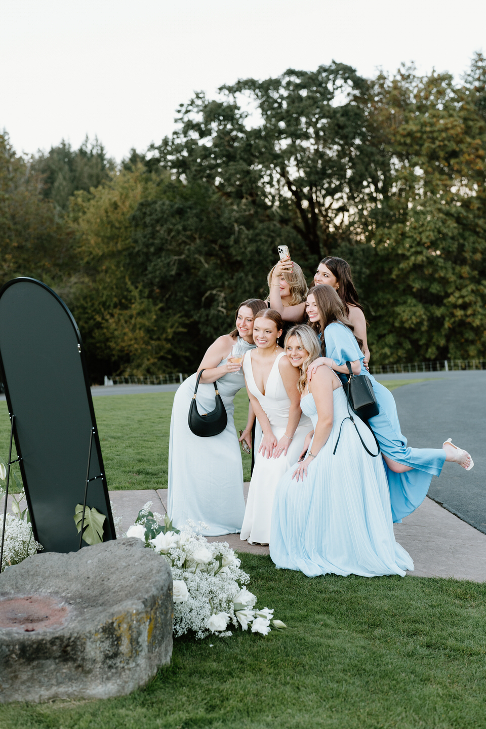 Bride and guests take photos in welcome mirror sign