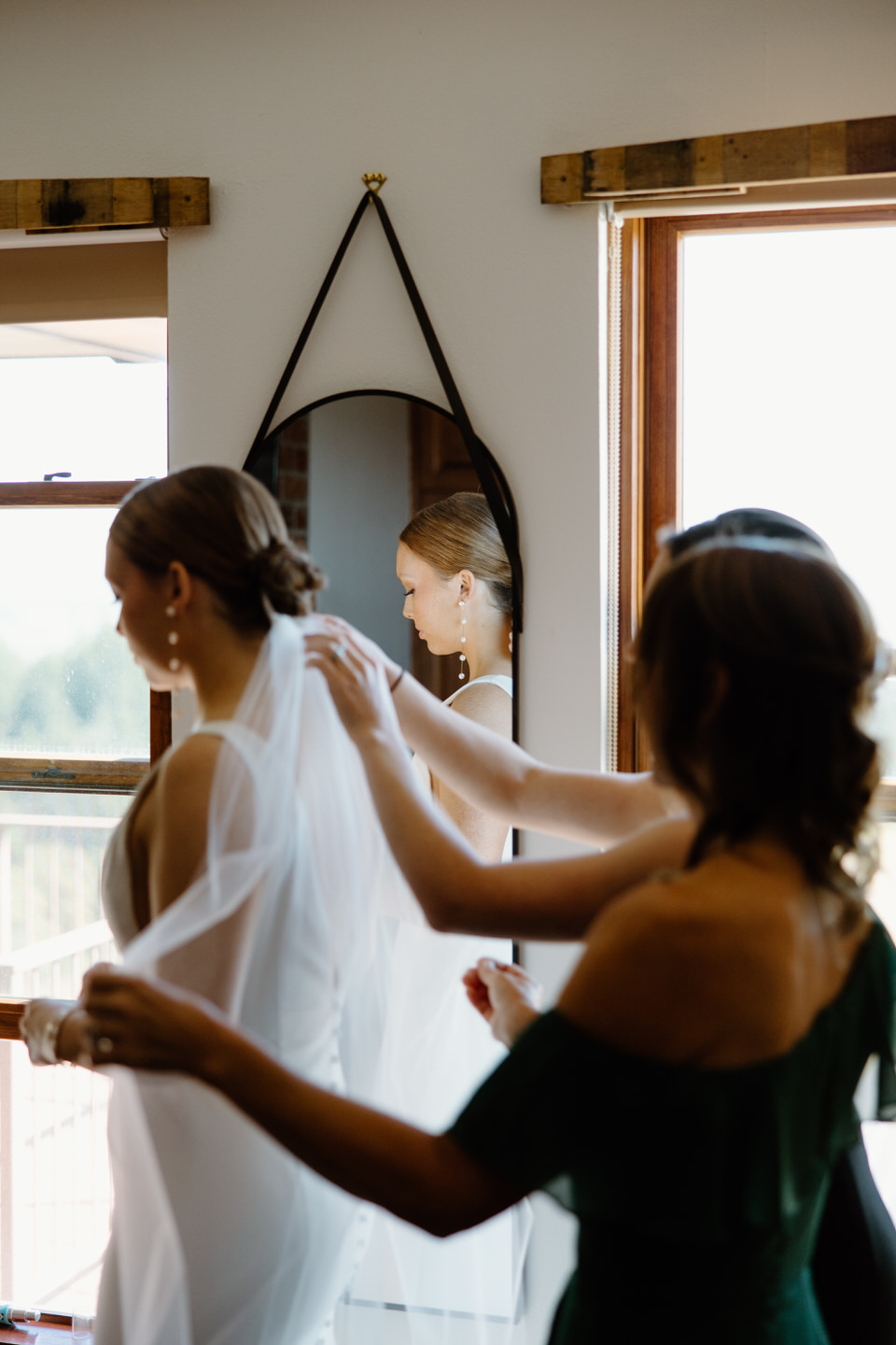 Mother of the bride putting the veil in bride's hair before Youngberg Hill wedding.