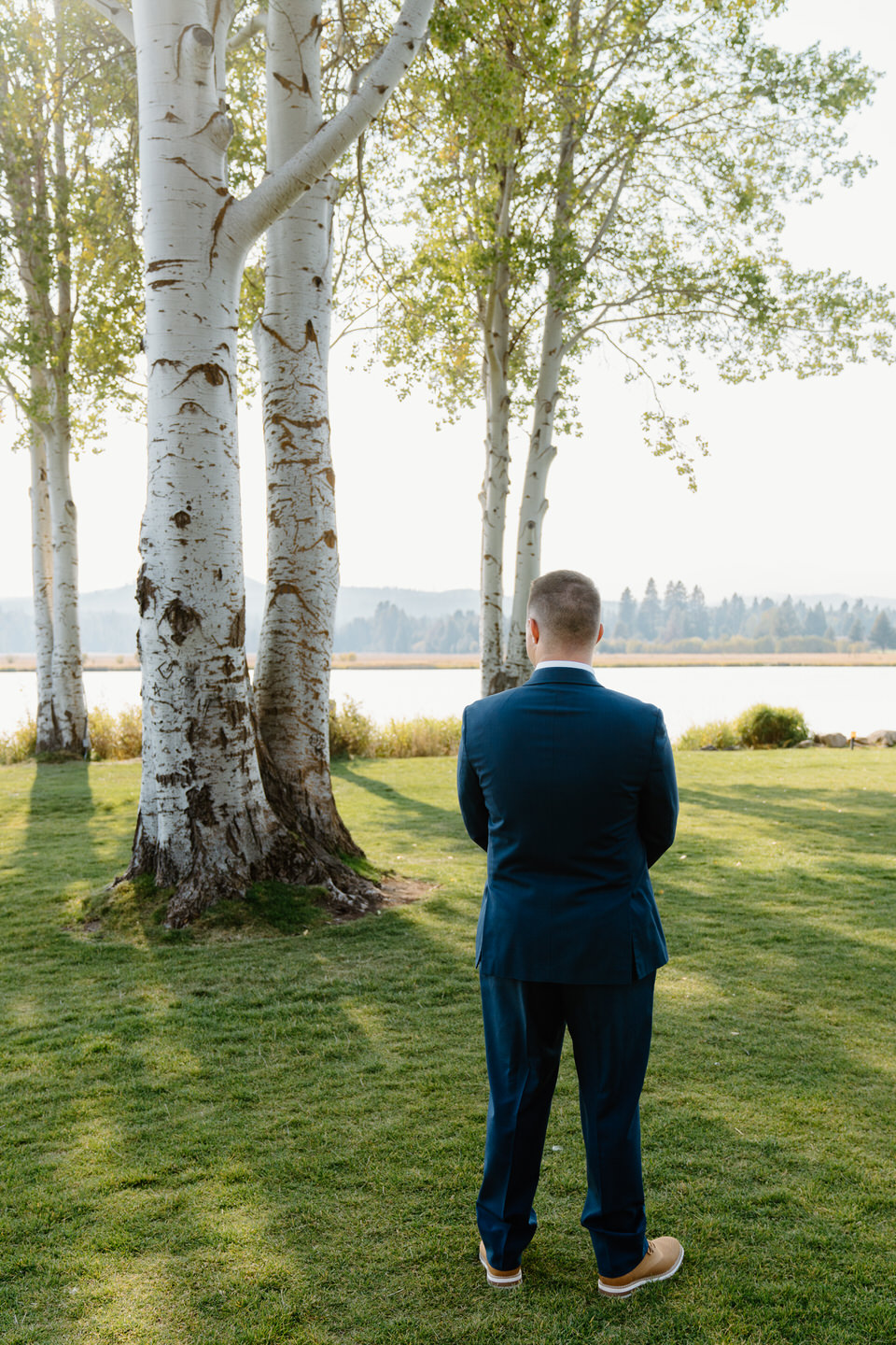 Central Oregon’s beauty surrounds a groom in a blue suit as he prepares for his wedding at Black Butte Ranch.