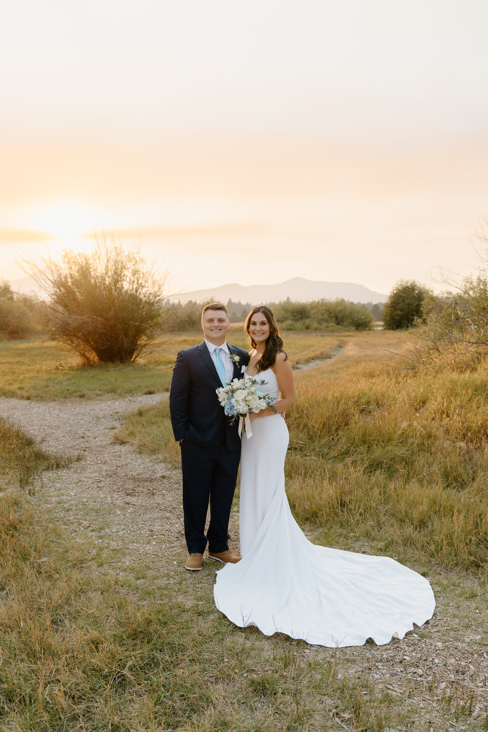 Bride and groom pose at sunset at their intimate Black Butte Ranch wedding among the glowing scenery.