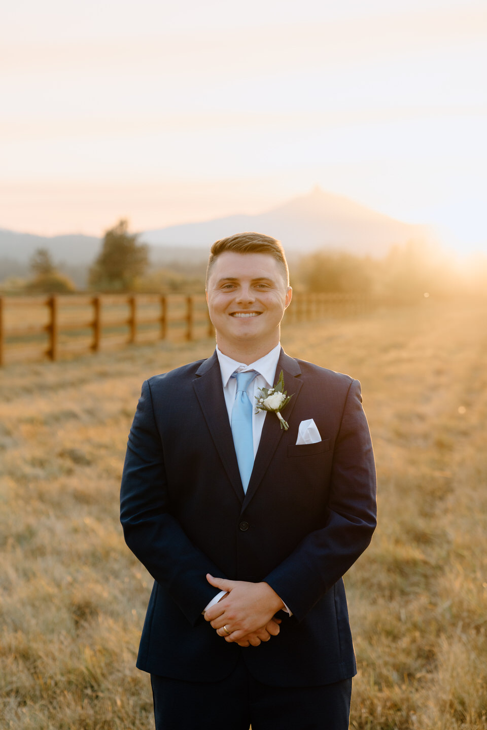 The groom, in a stylish blue suit, stands at Black Butte Ranch, blending elegance with Central Oregon’s rustic charm.