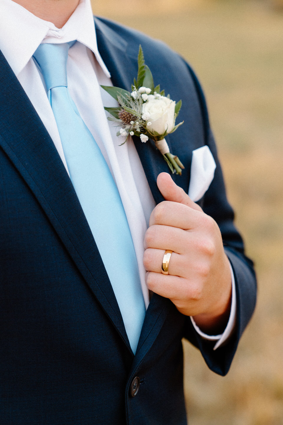 Groom in a classic blue suit poses at Black Butte Ranch, with Central Oregon’s natural beauty framing the moment.