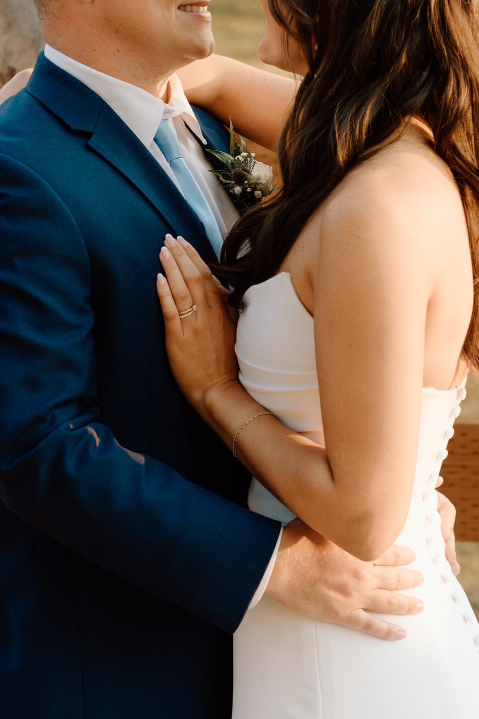 Close-up of the bride and groom posing at sunset, their skin glowing in the warm light with a dreamy Central Oregon backdrop.