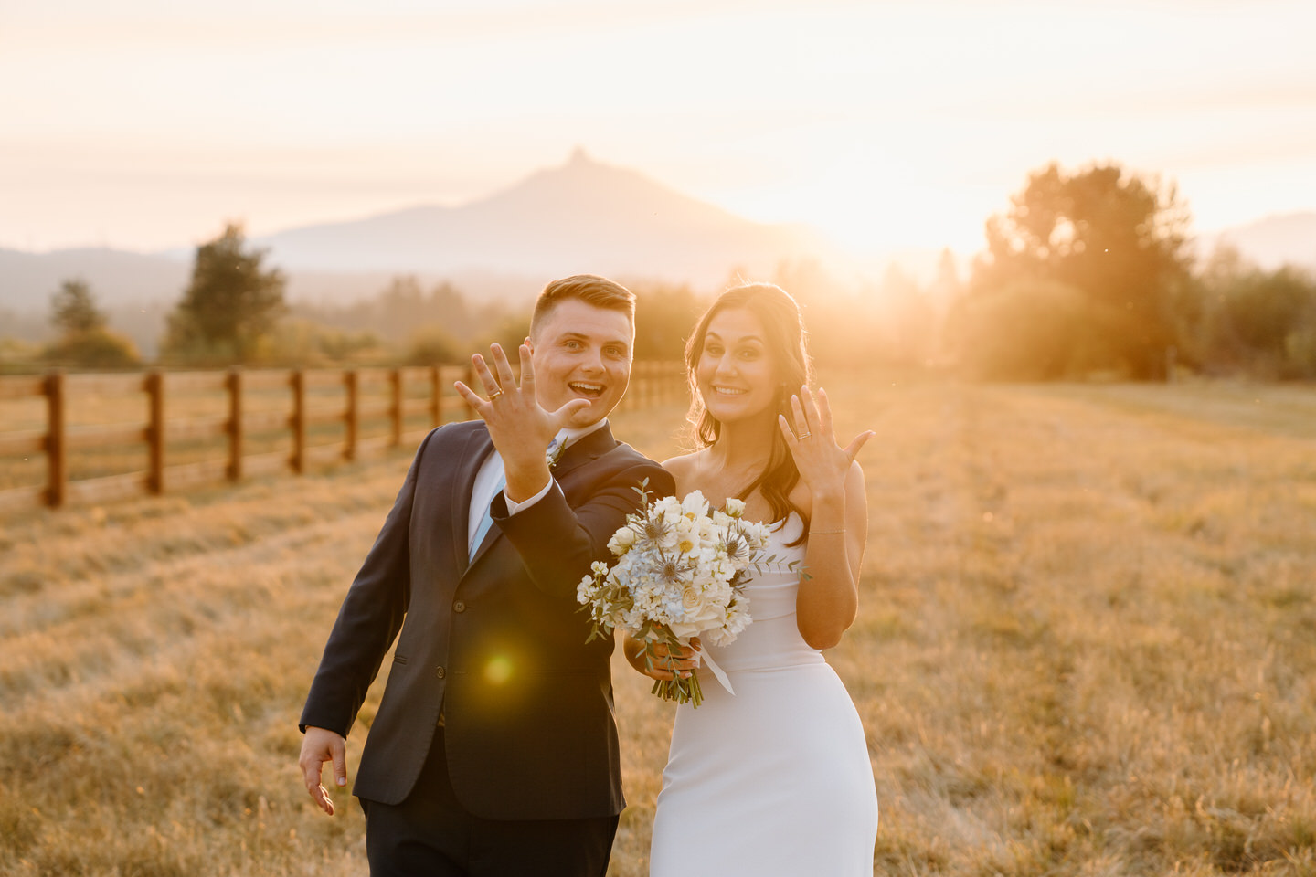 Bride and groom hold their rings up to celebrate their Black Butte Ranch Wedding