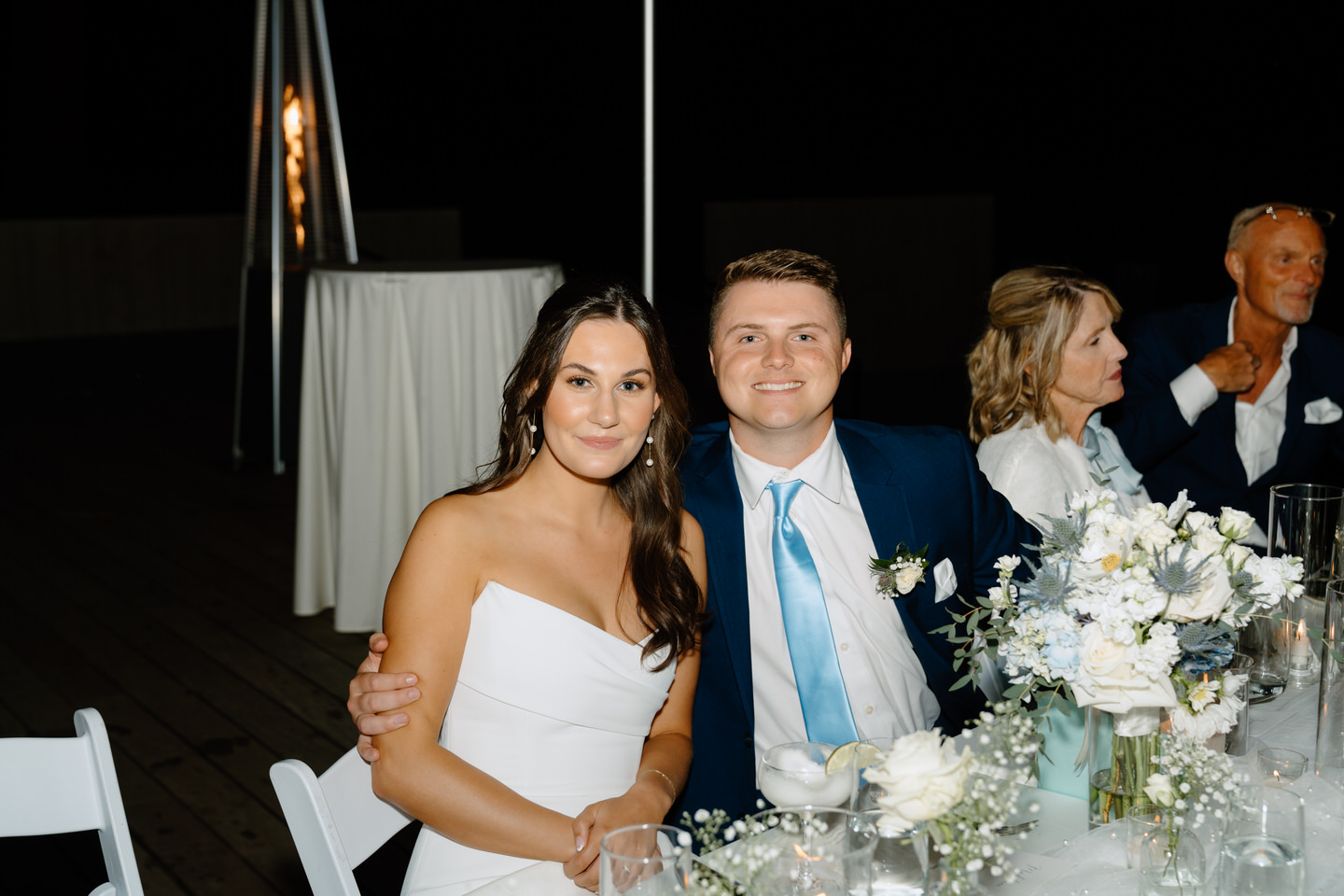 Bride and groom smiling for a photo at the dinner table during Central Oregon wedding.