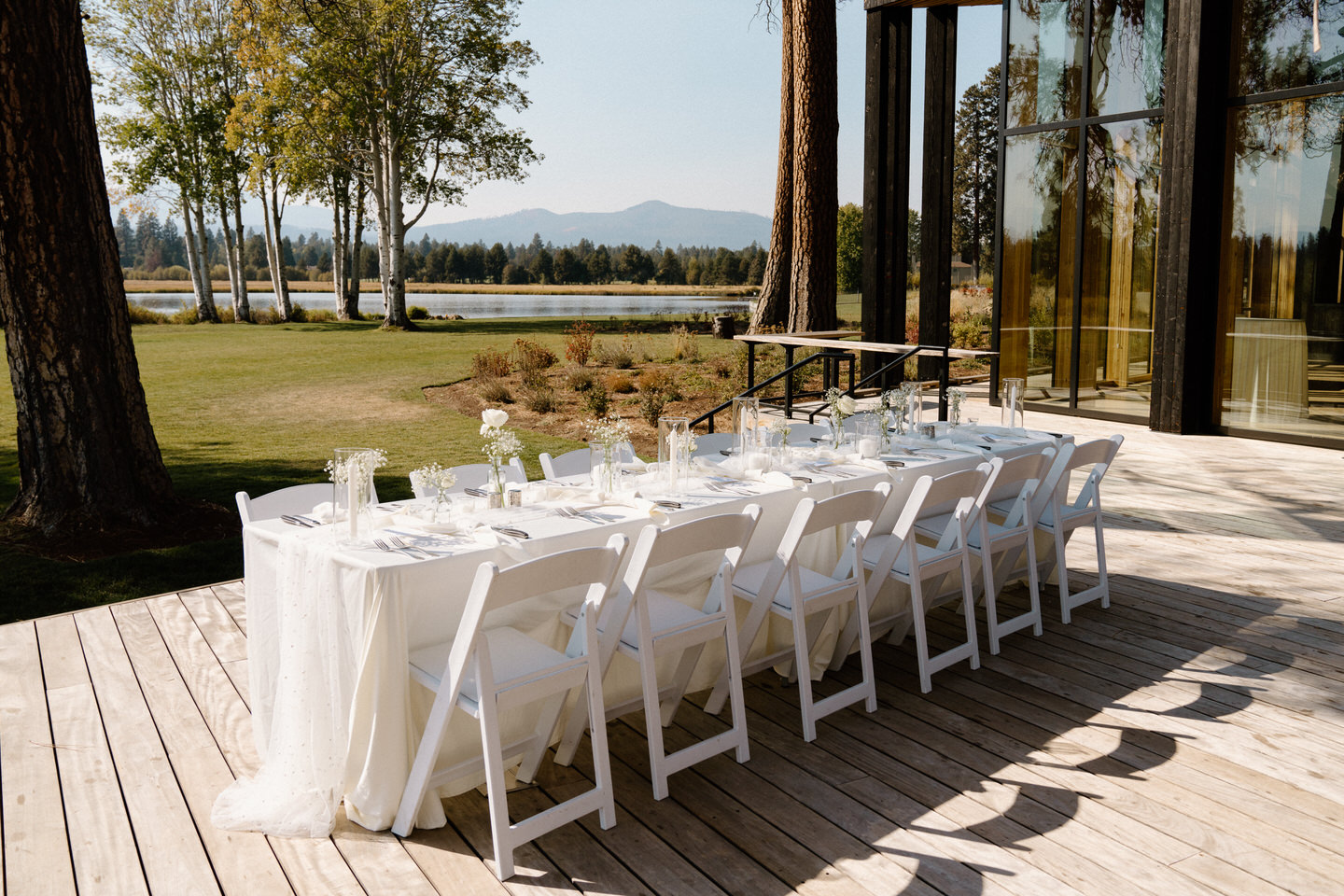 Long table with crisp white linens and simple glassware, styled for timeless elegance in Black Butte, Oregon.