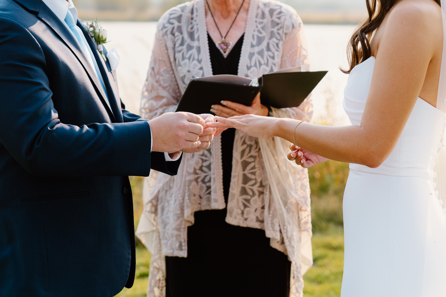 The bride and groom exchange rings during their Black Butte Ranch wedding, a close-up capturing the intimate and heartfelt moment.