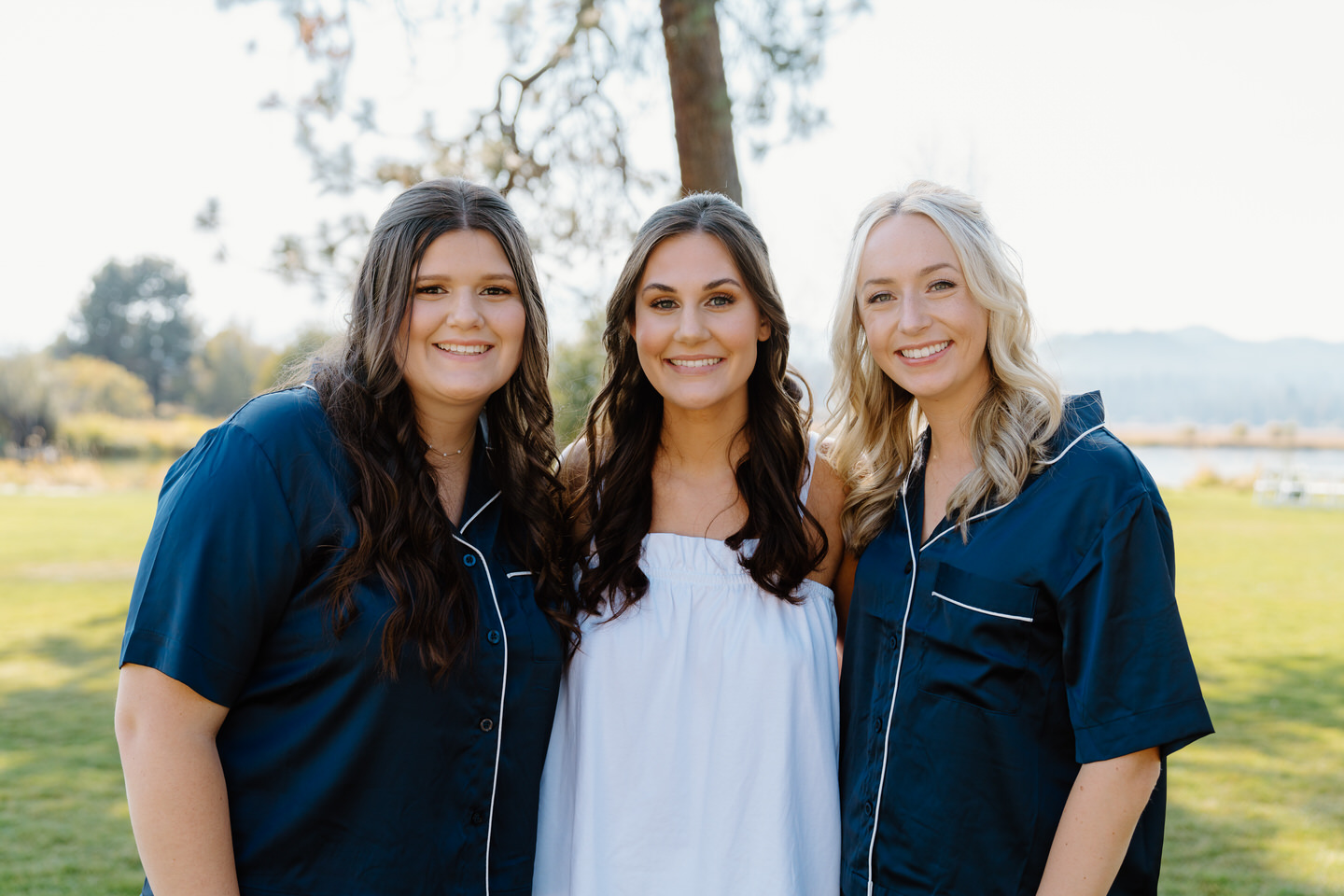 Bride and bridesmaids smile together in matching pajamas, sharing a joyful moment before getting ready at Black Butte Ranch.