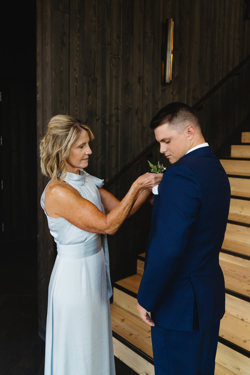 The groom’s mom carefully pins his boutonniere, a tender moment captured before the ceremony at Black Butte Ranch.