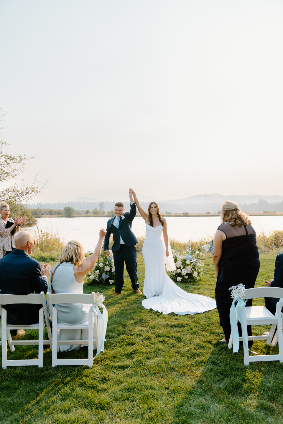 Bride and groom cheer joyfully after their ceremony at Black Butte Ranch, surrounded by guests and the stunning Central Oregon landscape.