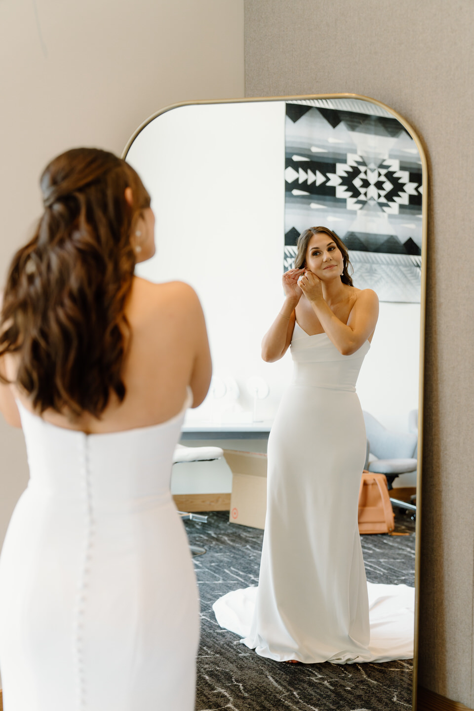 The bride delicately puts on her earrings, a serene moment captured as she prepares for her wedding day at Black Butte Ranch.