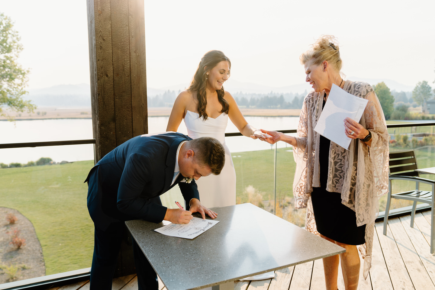 Groom signs the marriage license on the upper deck of Black Butte Ranch's lodge.