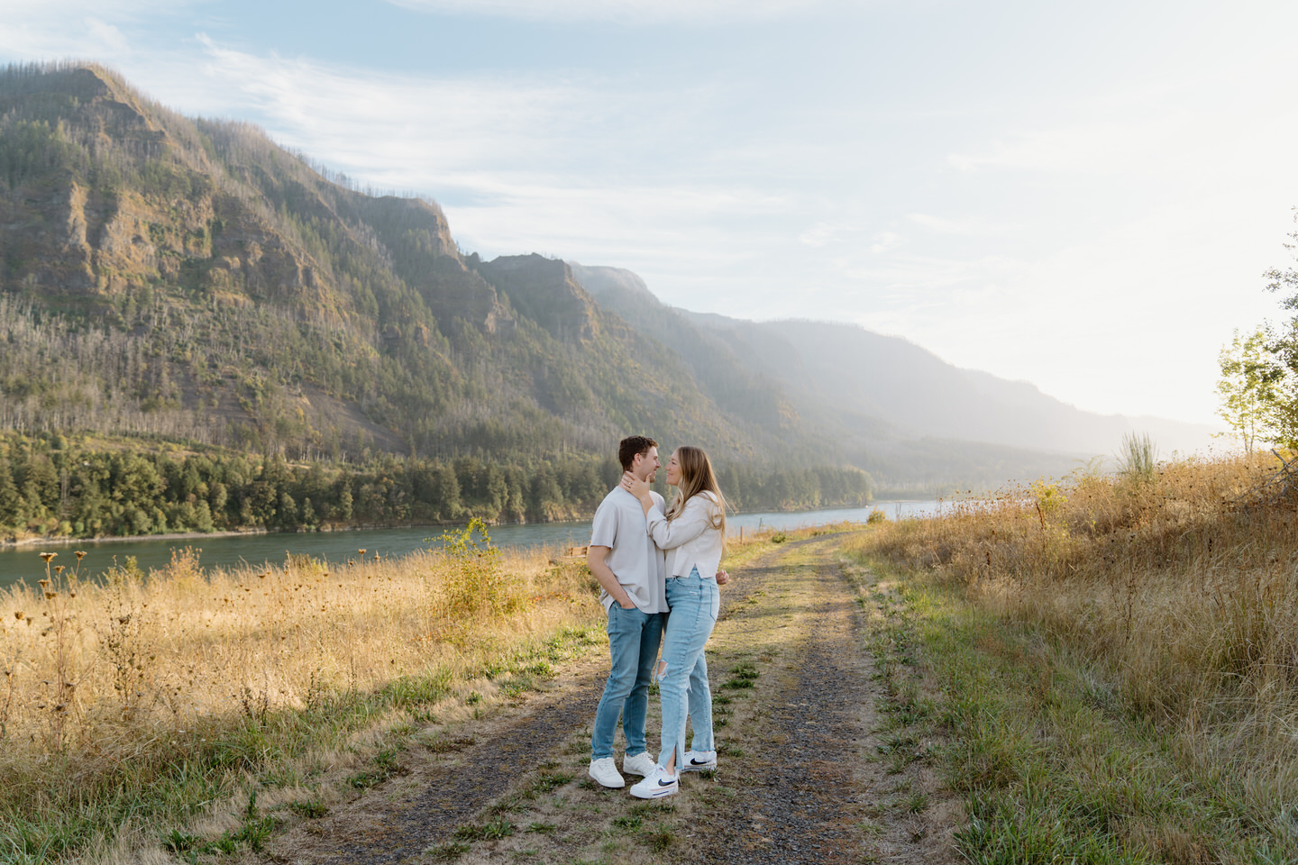 She gently holds his face as they share a tender moment, surrounded by the beauty of the Columbia Gorge in September.