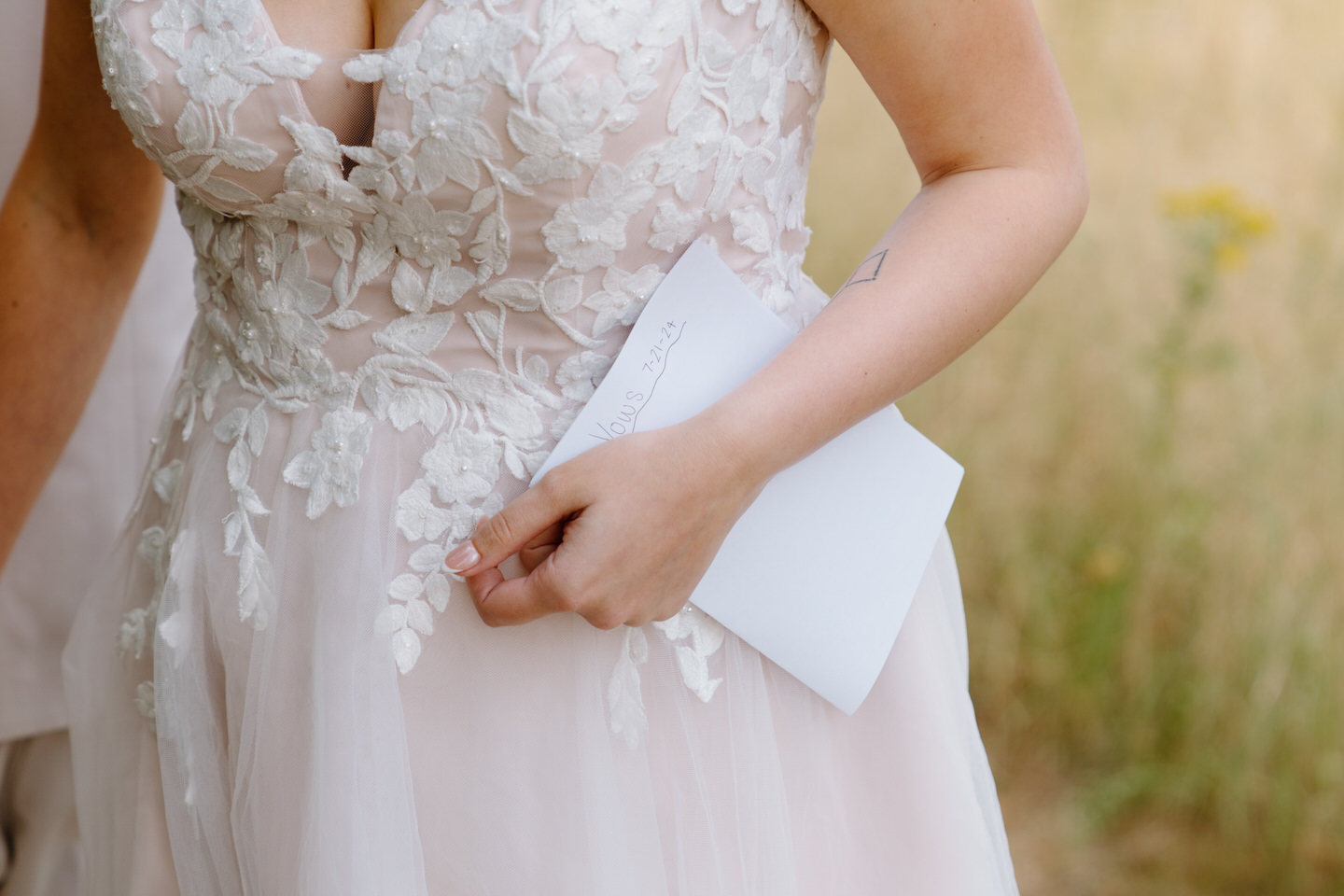 Bride holds her handwritten vow book during first touch at their Oregon wedding.