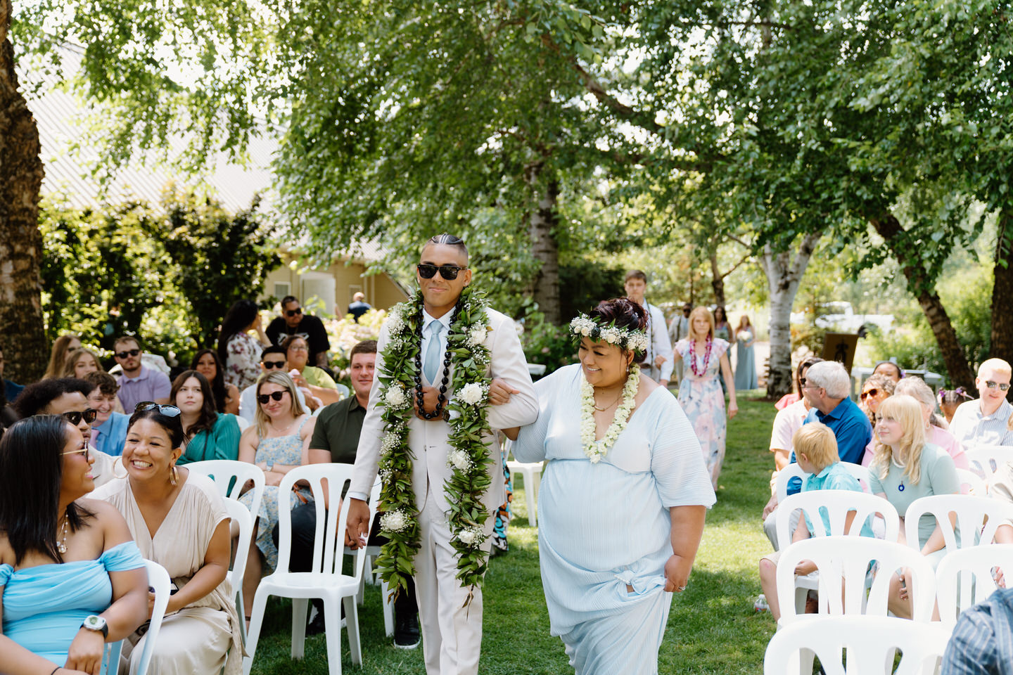 Groom and his mother walk down the aisle together, moments before the wedding ceremony at Green Villa Barn.