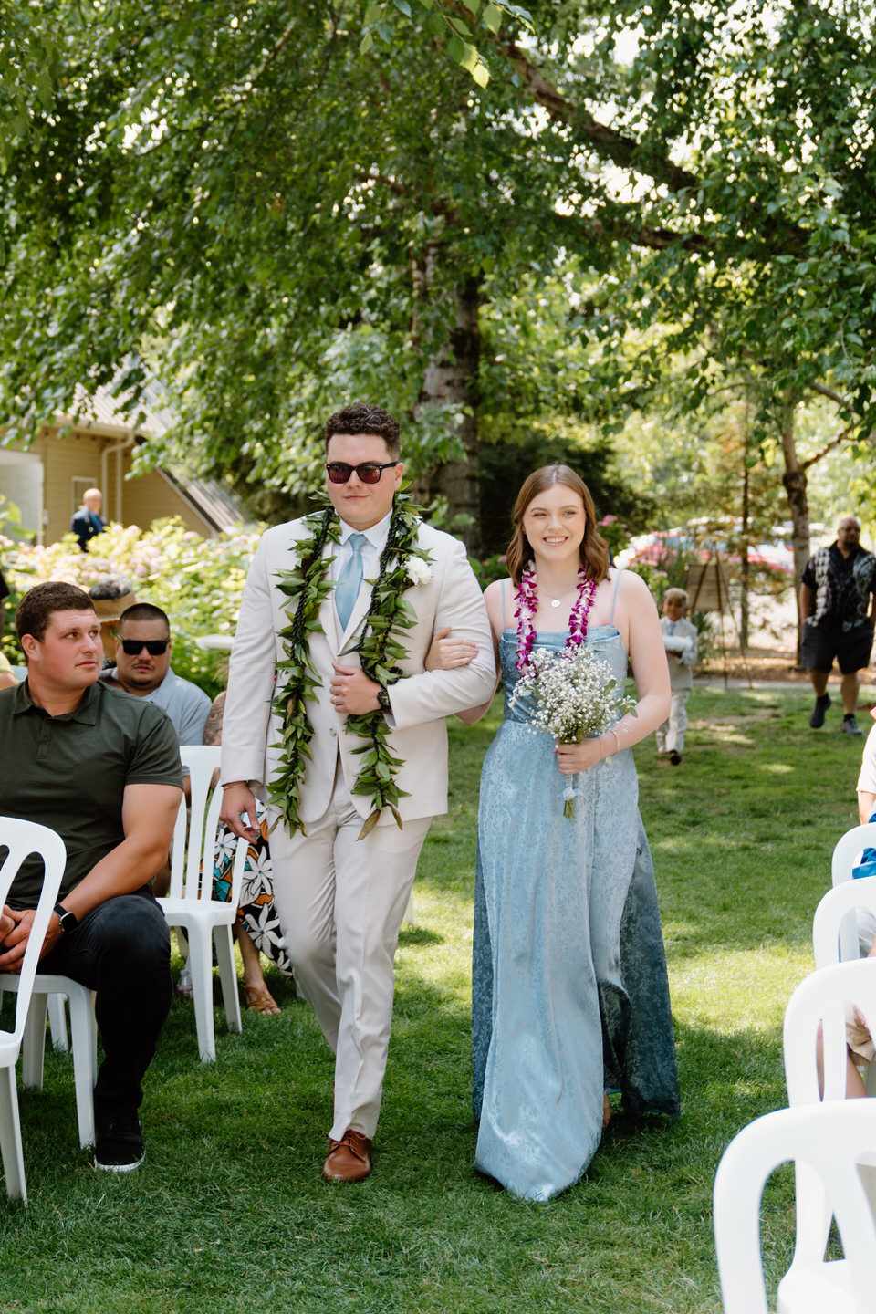 Maid of honor and best man walk down the aisle, leading the way for the couple's Oregon wedding at Green Villa Barn.