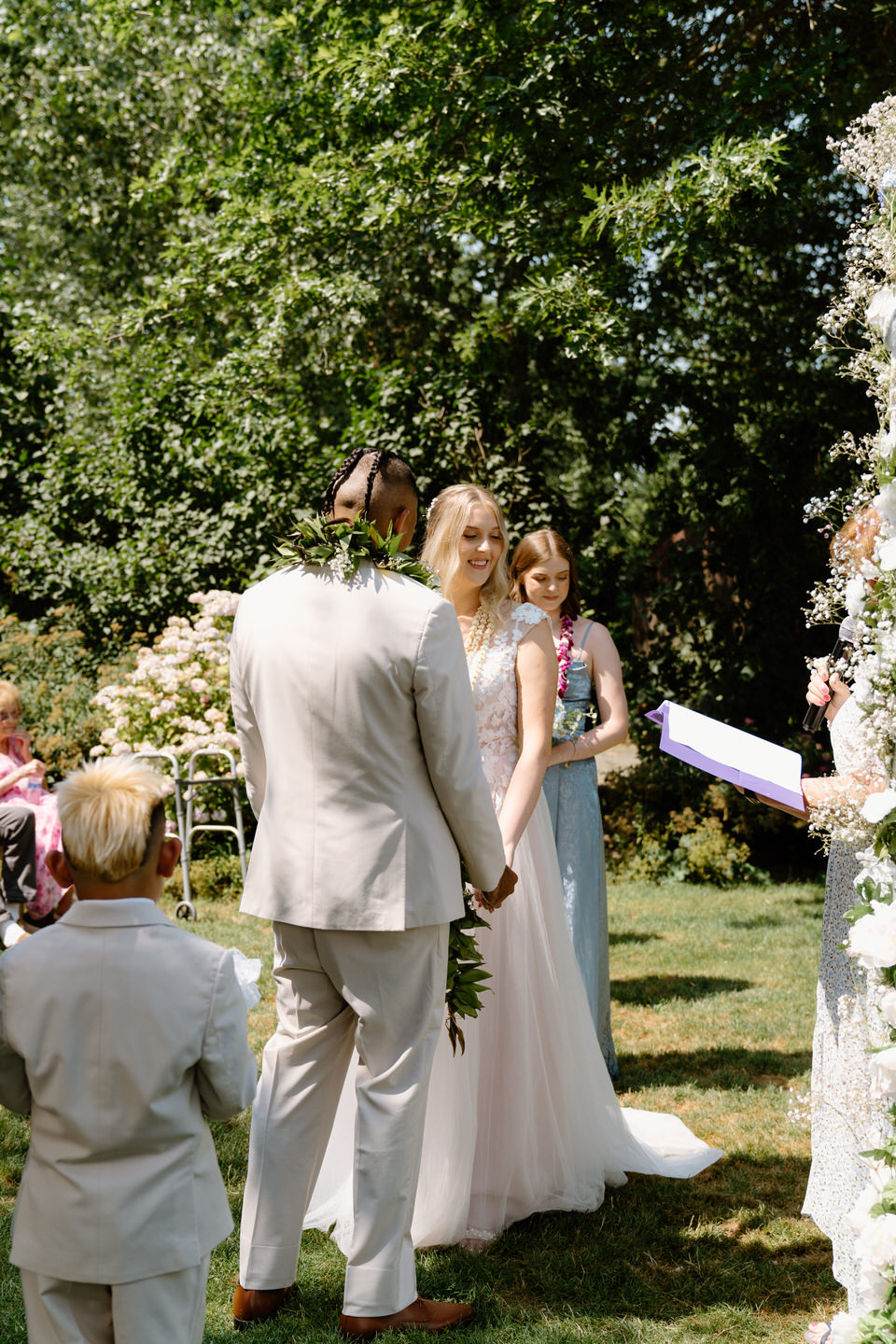 Bride and groom stand together at the altar, exchanging vows during their Oregon wedding at Green Villa Barn.