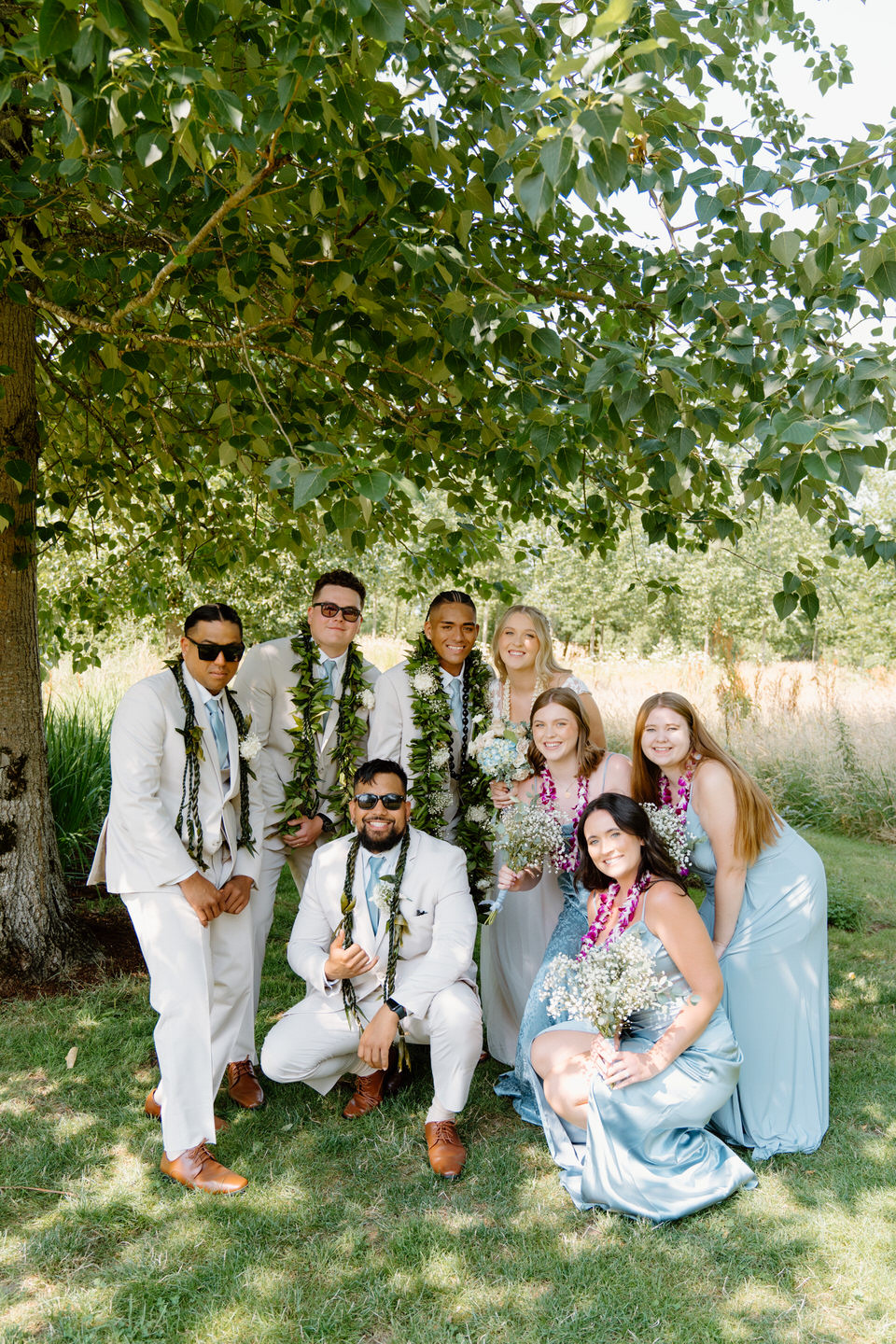 Wedding party poses in a group with Hawaiian leis.