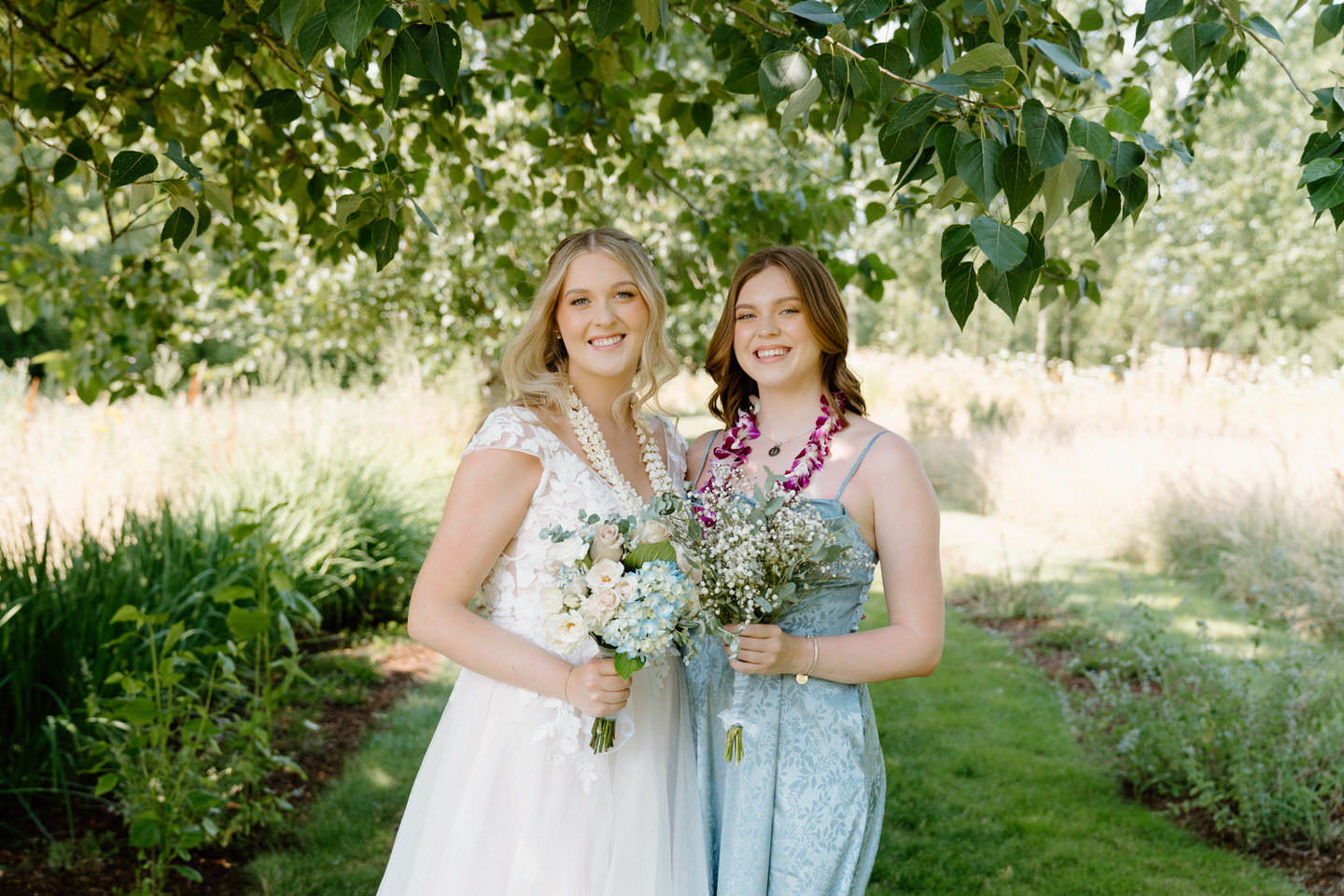 Bride and her maid of honor sharing the joy of wedding day.