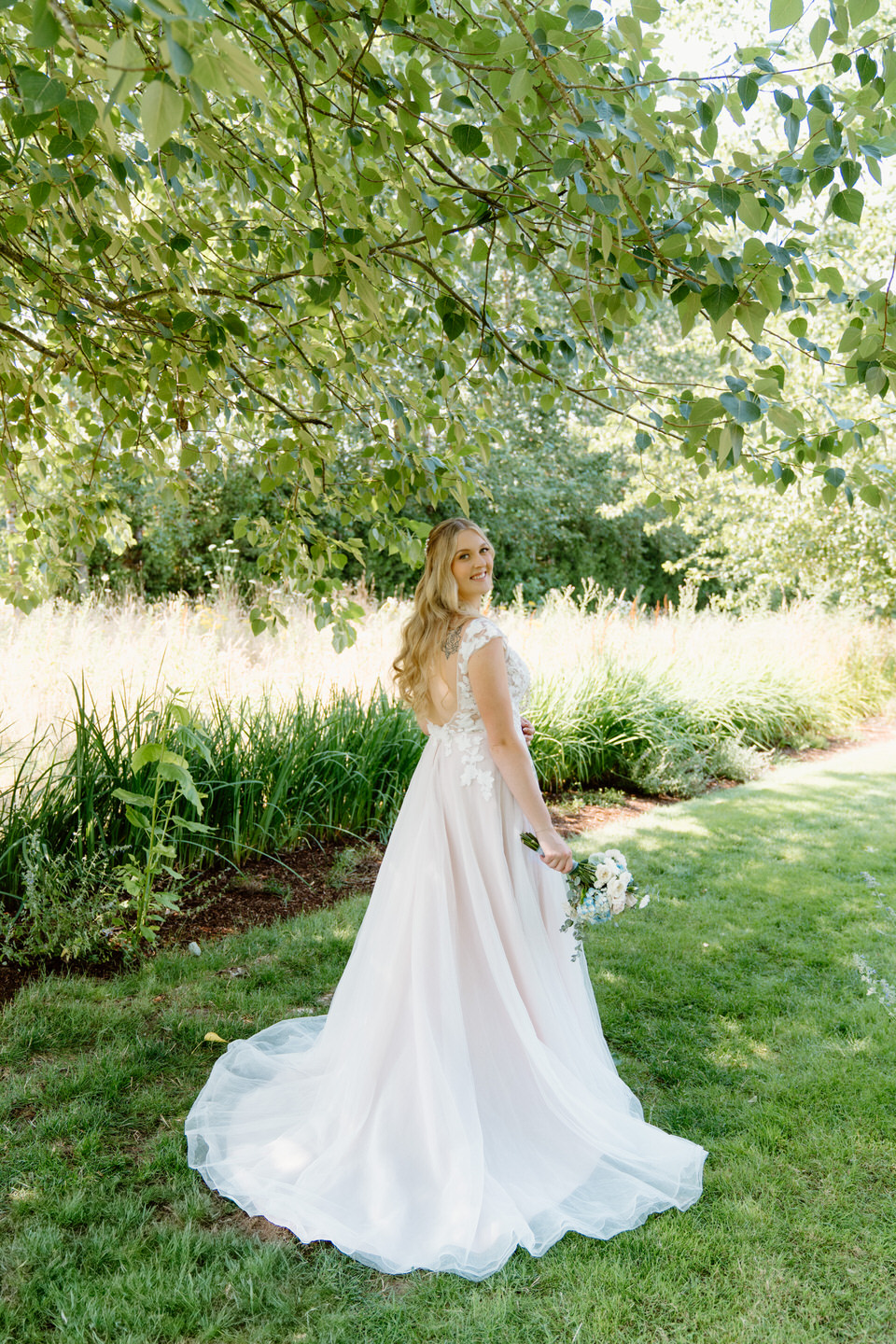 The bride poses gracefully in her wedding gown, capturing the beauty of her solo portraits at Green Villa Barn, Oregon.