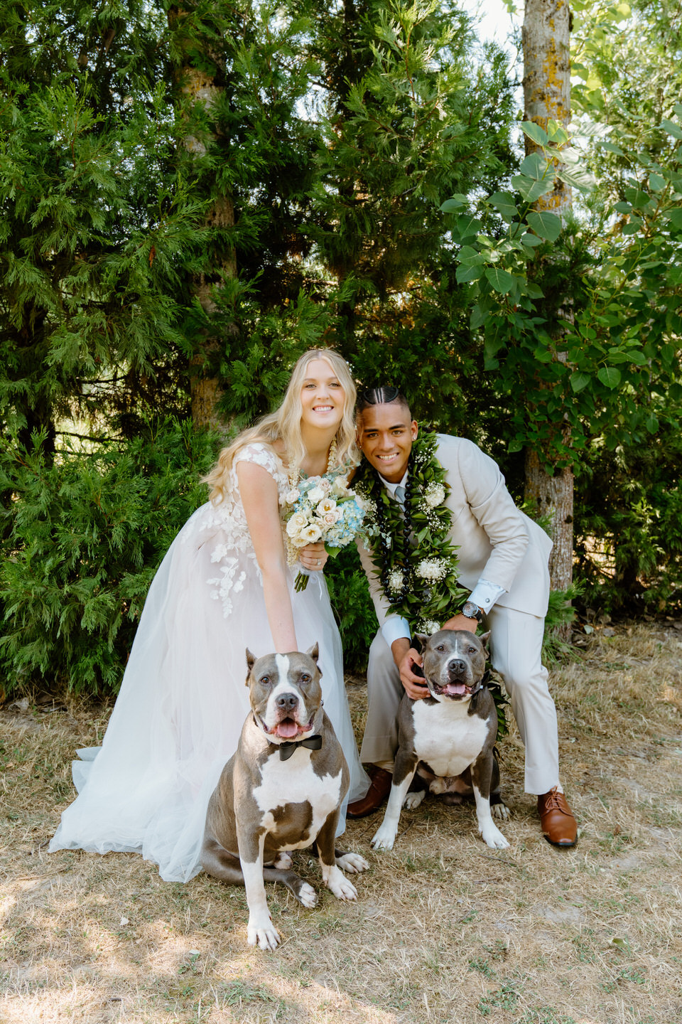 The couple poses with their dogs, adding a personal and playful touch to their Green Villa Barn wedding photos.