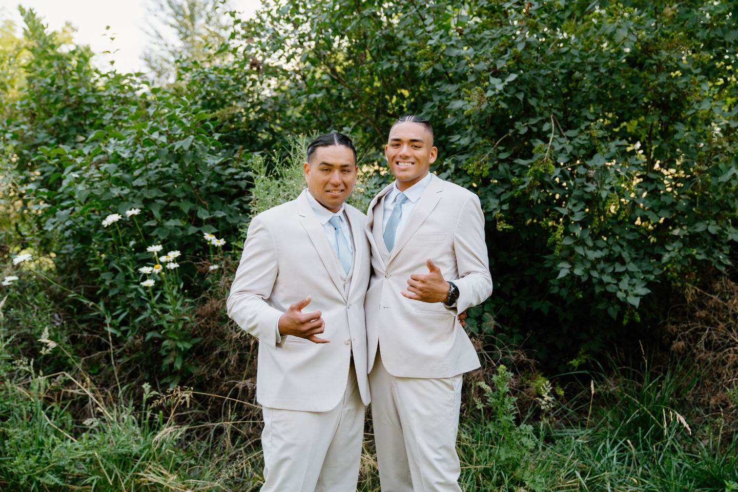 Groom and his groomsman posing in front of the garden at Green Villa Barn.