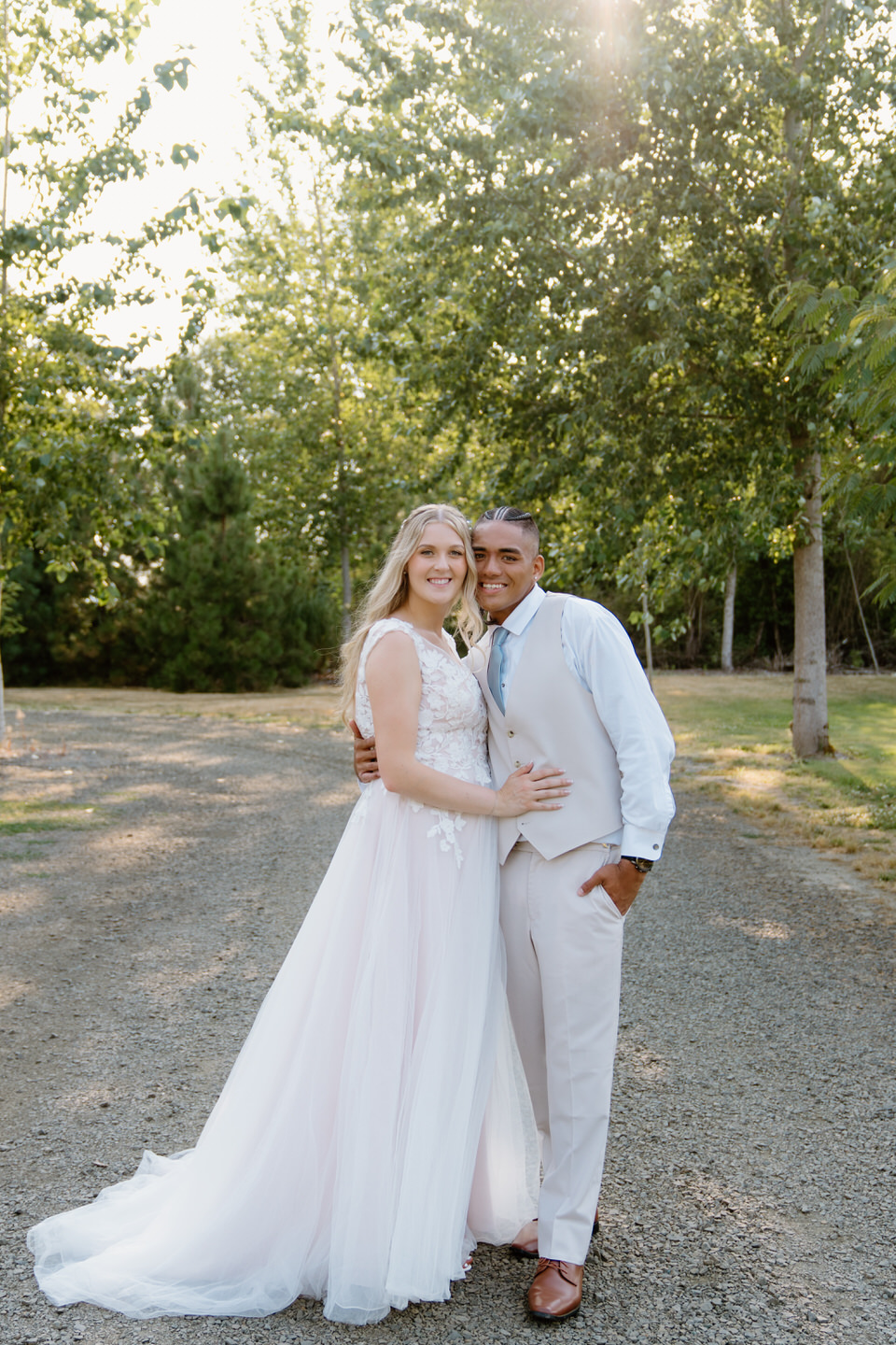 Bride and groom share a quiet moment in the sun-kissed garden at Green Villa Barn during their summer wedding portraits.