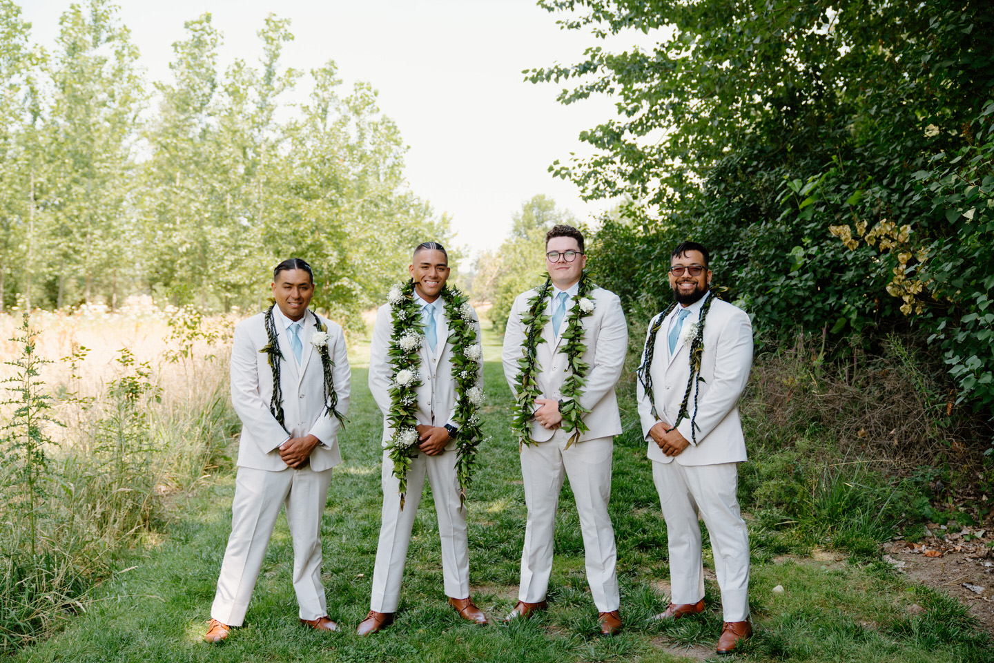 Groom looks dashing in his suit as he stands confidently in the garden for his wedding portraits at Green Villa Barn.