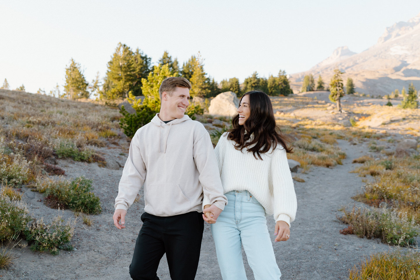 Playful couple walking down the gravel trail at Timberline Lodge in the early fall.