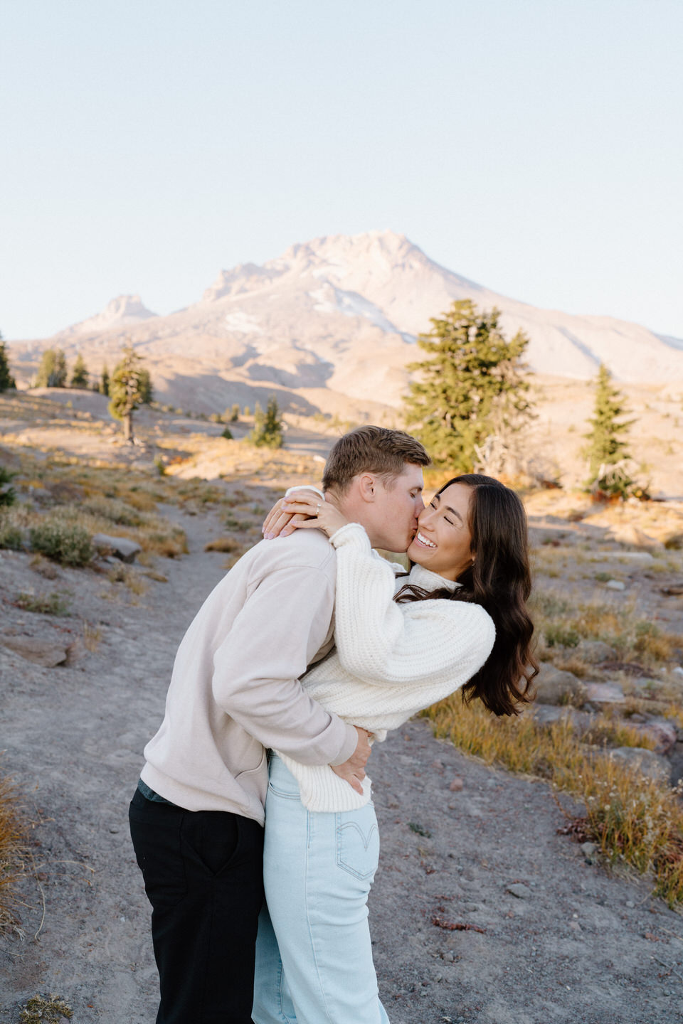 The man leaning over to kiss his wife on the cheek on Mount Hood near Timberline Lodge.