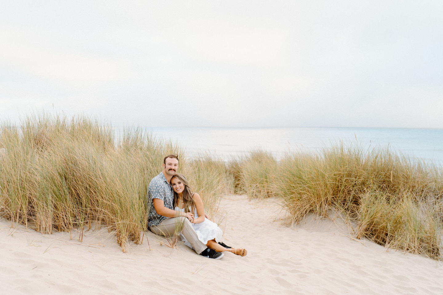 Oregon Coast engagement session sitting in front of tall seagrass