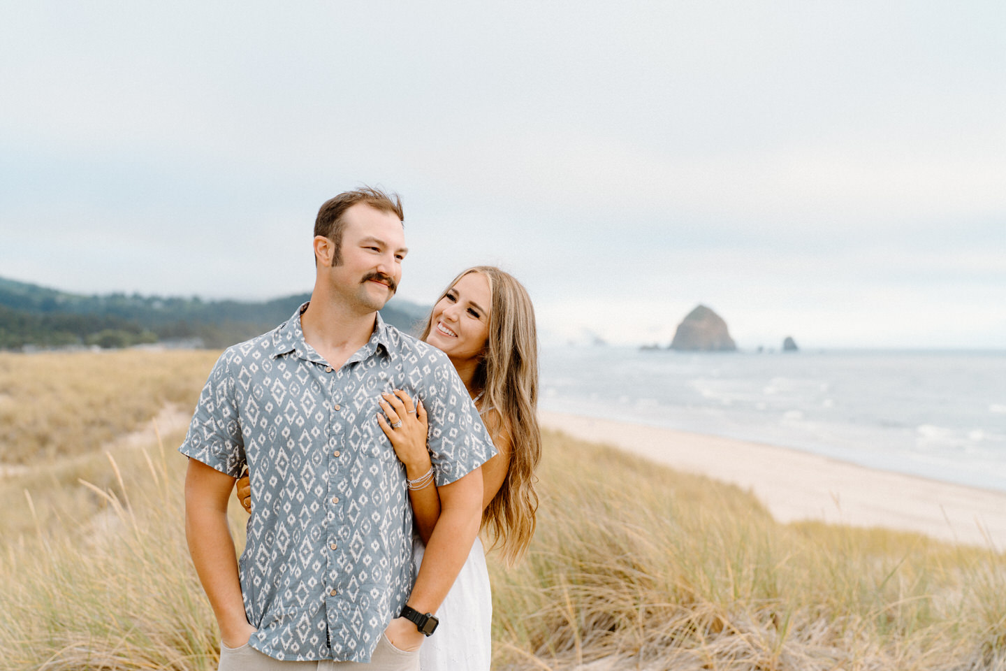 Oregon coast engagement photos with Cannon Beach in the distance