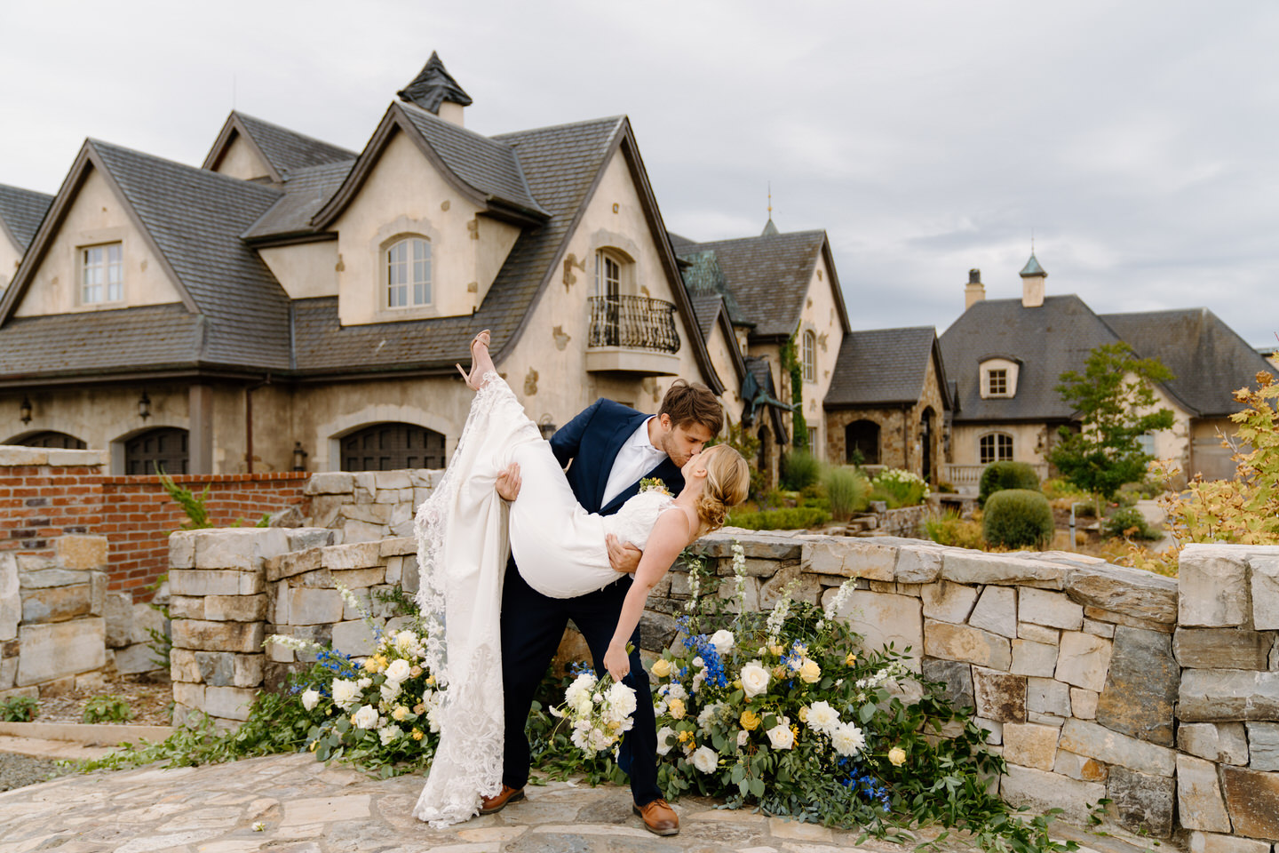 Groom carrying his bride through the garden at the Chateau de Lis, one of the best luxury wedding venues in Oregon. 